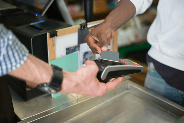 persona pagando con tarjeta en una maquina pos